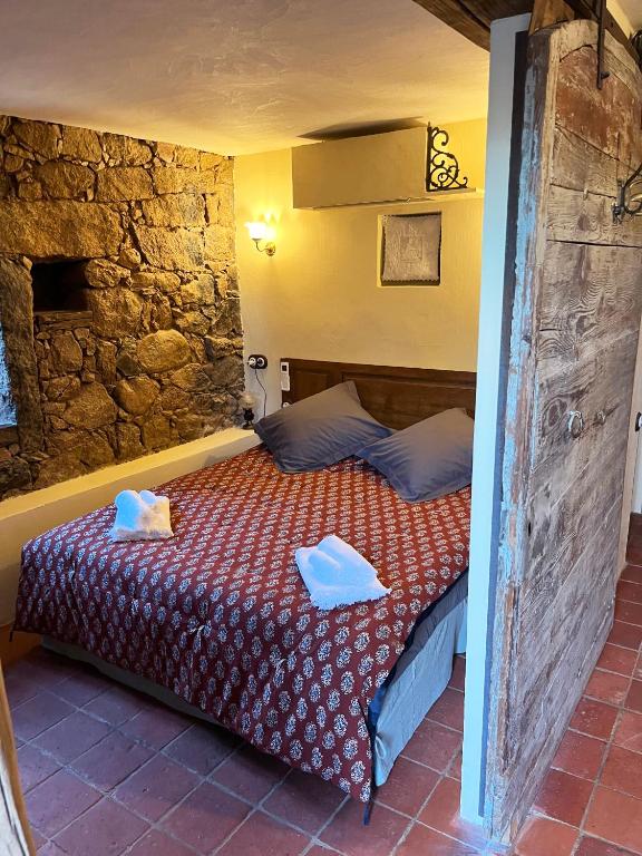 a bedroom with a bed with two towels on it at Domaine de la coletta Maison traditionnelle in Coti-Chiavari
