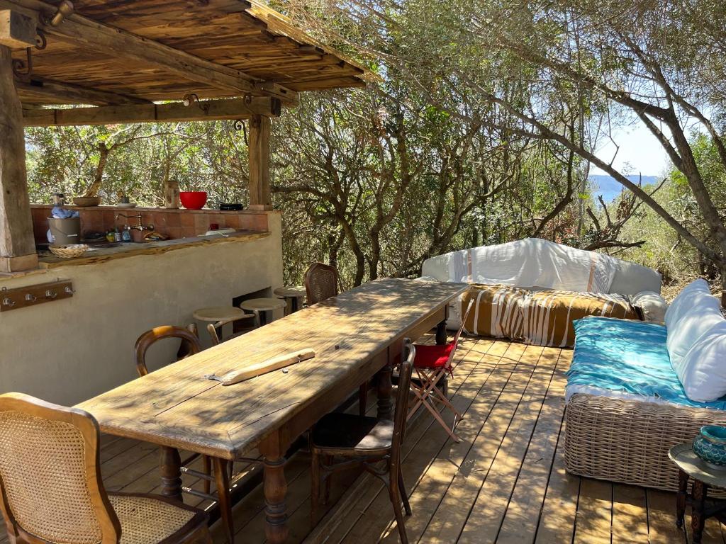 a wooden table and chairs on a patio at Domaine de la coletta Maison traditionnelle in Coti-Chiavari