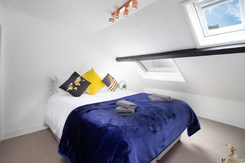 a bedroom with a bed with a blue blanket at Modern Quirky Exeter City Cottage 2 min walk - shops in Exeter