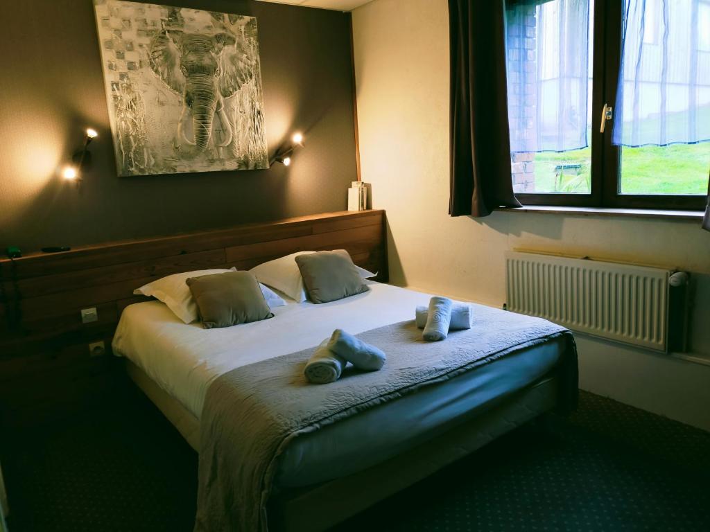un dormitorio con una cama con dos animales de peluche en Hôtel Restaurant l’Éolienne, en Rouxmesnil-Bouteilles