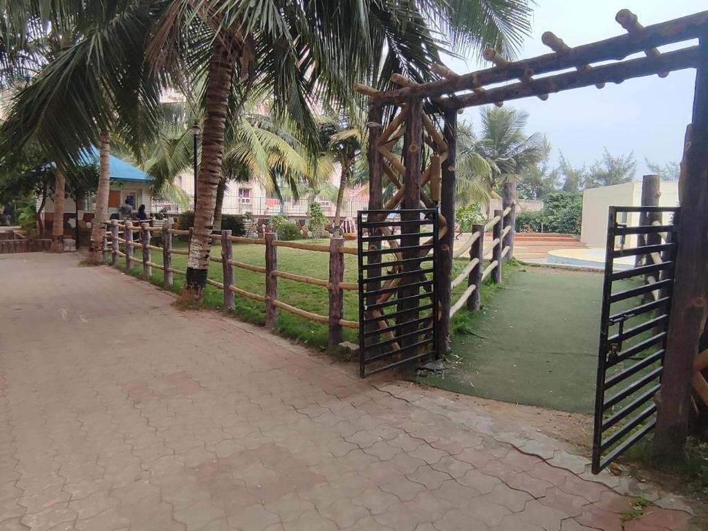 una valla de madera con una puerta y palmeras en Platinum Stay, en Puri