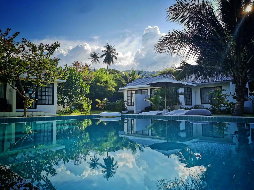 a villa with a swimming pool in front of a house at Silan Residence, Koh Phangan - An authentic village experience in Chaloklum