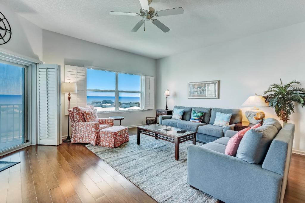 a living room with a blue couch and chairs at Ocean View Arcane Condo in Fernandina Beach