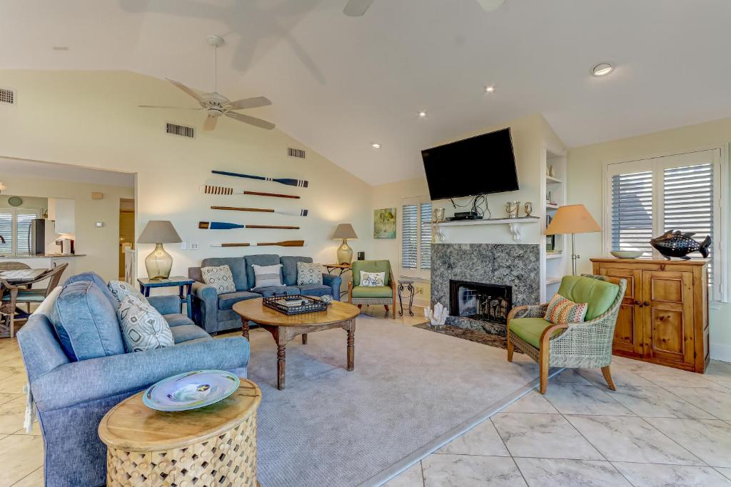 a living room with a blue couch and a fireplace at Fletcher Family Friendly Home in Fernandina Beach