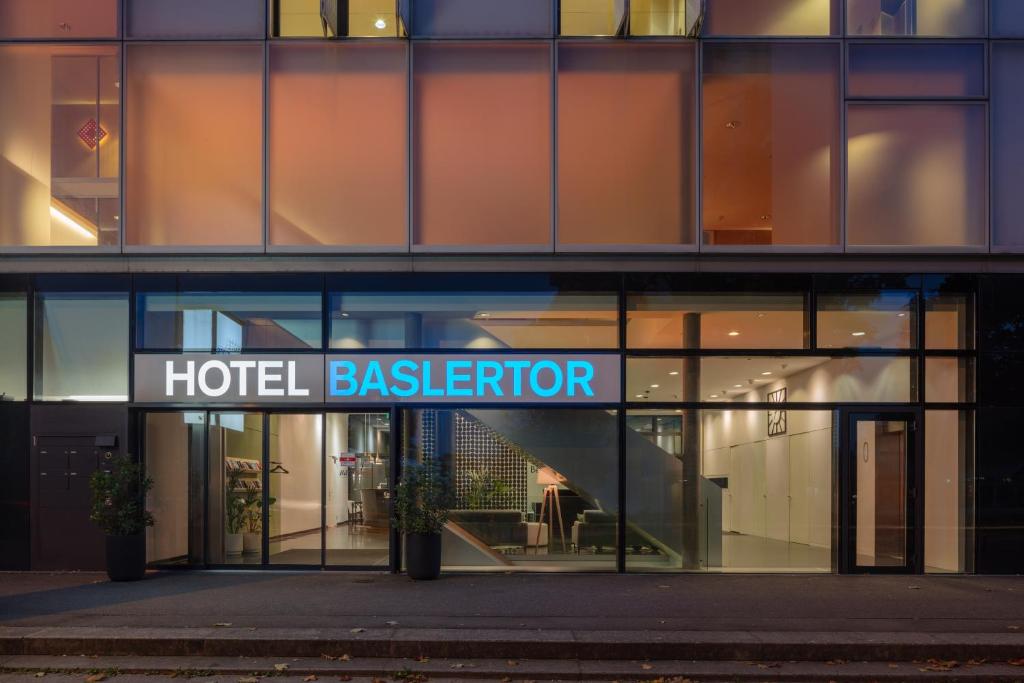ein Hotelgebäude mit einem Schild, das das Hotel hinter der Bühne liest in der Unterkunft Hotel Baslertor in Muttenz