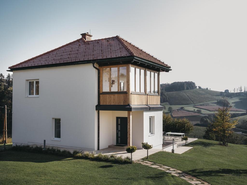 ein kleines weißes Haus mit einem Holzdach in der Unterkunft Das Dietrich - Landhaus 58 in Leibnitz