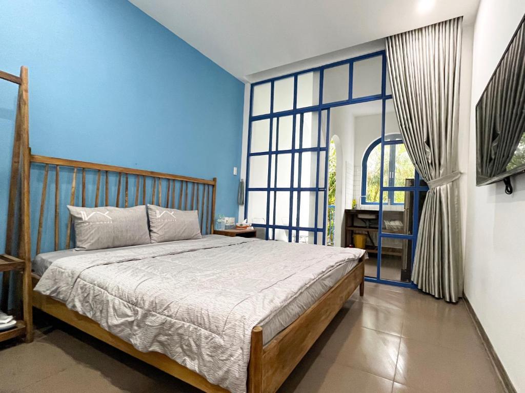 ein Schlafzimmer mit einem Bett und einem großen Fenster in der Unterkunft Ivy house in Hue