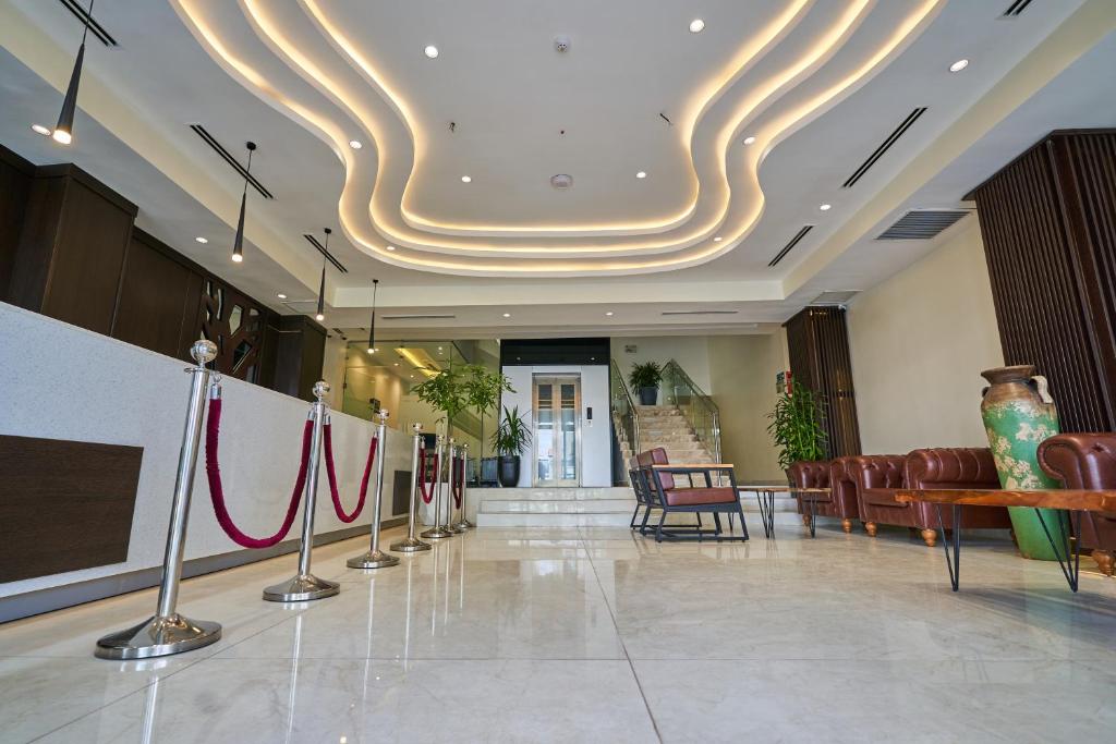 a lobby with chairs and a table and a ceiling at Monty Suites Lekki in Lagos