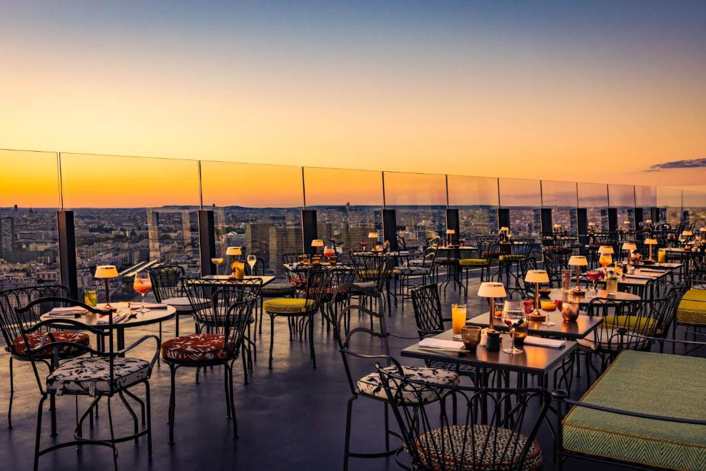 a restaurant with tables and chairs on top of a building at Too Hotel Paris - MGallery in Paris