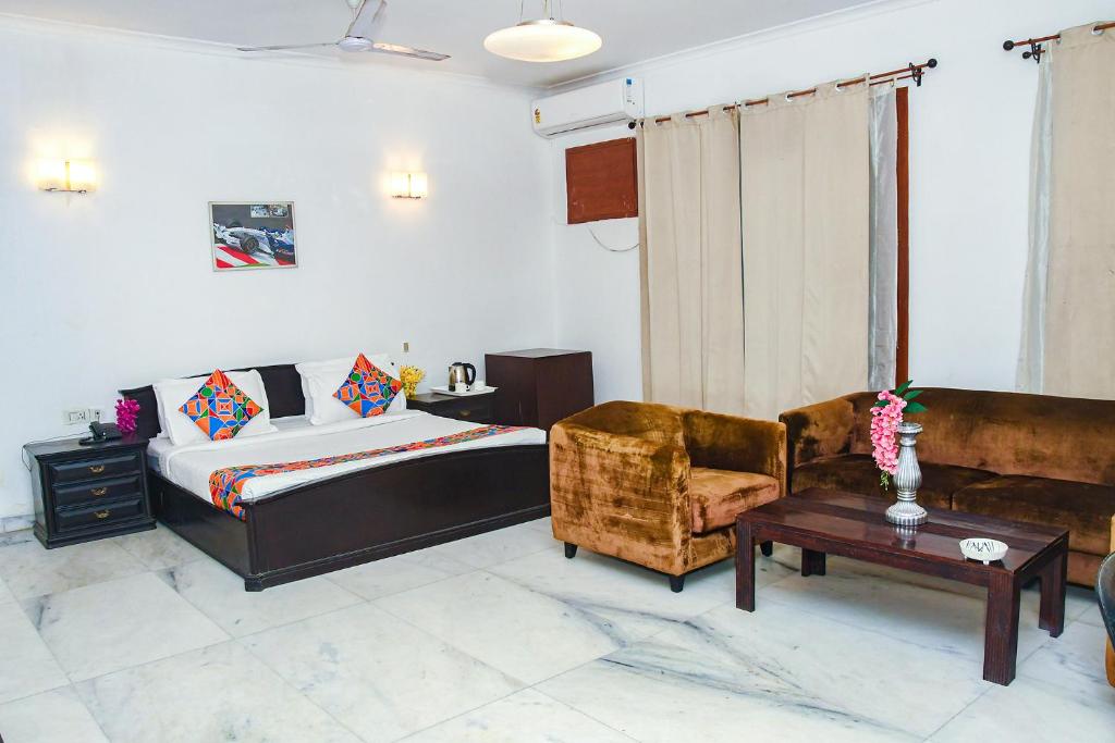 - une chambre avec un lit, un canapé et une table dans l'établissement FabHotel Premium, à Gurgaon