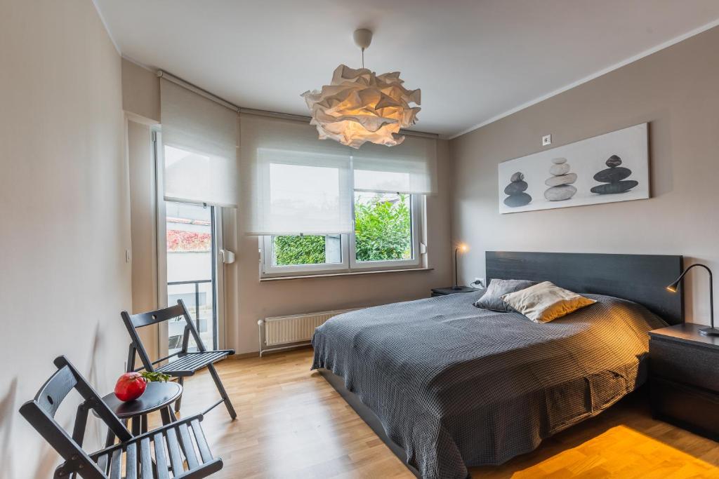 1 dormitorio con 1 cama, 2 sillas y lámpara de araña en Vila Valentina, en Liubliana