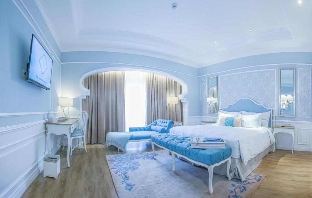 um quarto com uma cama king-size e um sofá em Noor Hotel em Bandung
