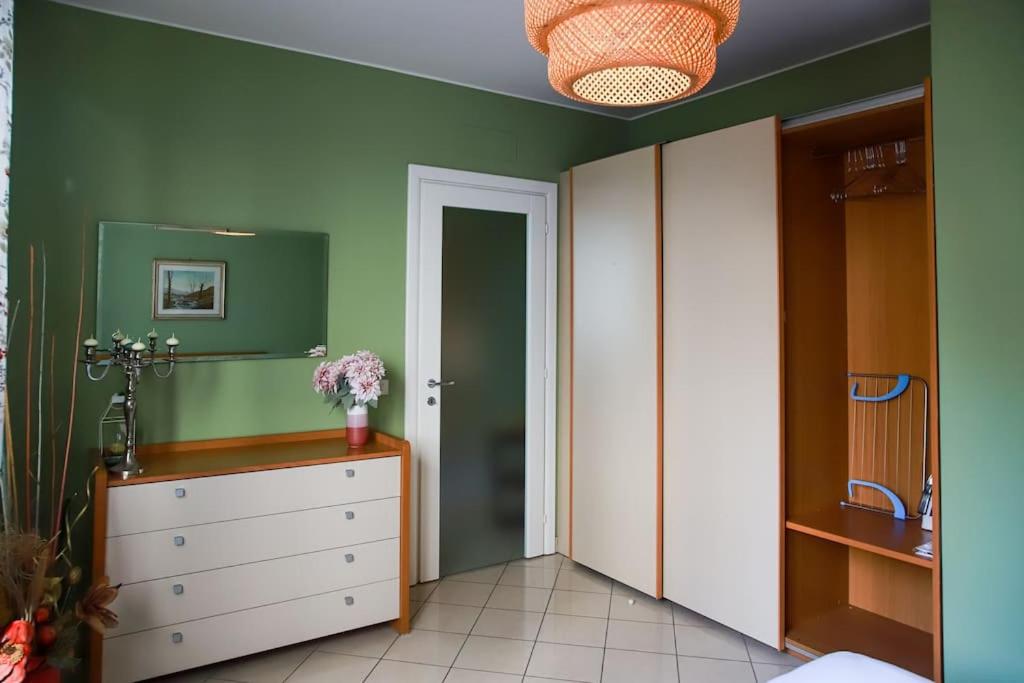 una camera da letto con cassettiera e parete verde di Appartamento per 4 persone in centro Alba ad Alba