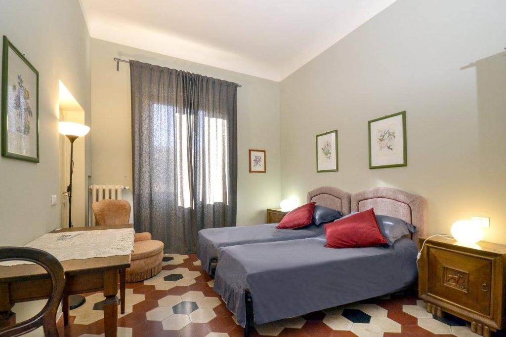 1 dormitorio con 2 camas, mesa y silla en Palazzo Panzani, en Florencia
