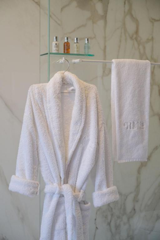 a white robe and towels on a rack in a bathroom at RM The Experience - Small Portuguese Hotels in Setúbal