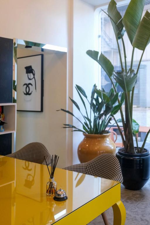 a yellow table with two potted plants on it at RM The Experience - Small Portuguese Hotels in Setúbal