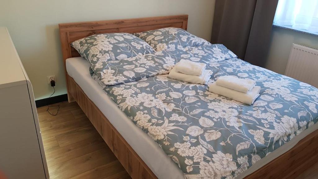 1 cama con manta azul y blanca y 2 almohadas en Apartamenty Homely - Nowowarszawska 130, en Białystok
