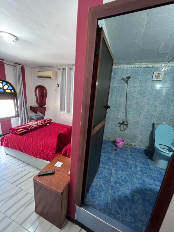 a bedroom with a bed and a shower and a toilet at Hotel Sevilla in Chefchaouene