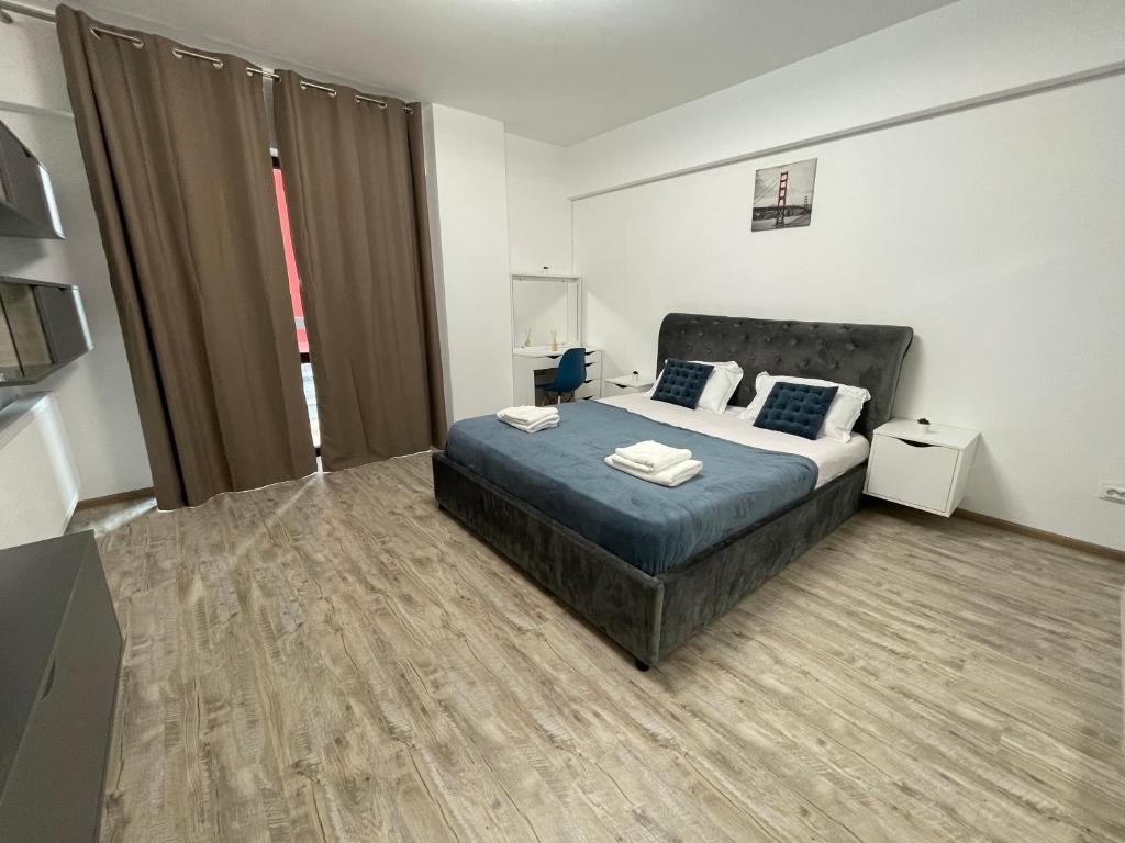 een slaapkamer met een bed in een kamer bij Iulius Mall River Tower in Iaşi