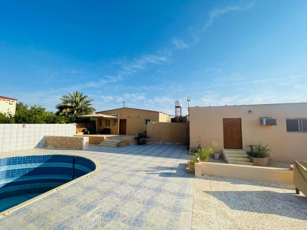 einen Hinterhof mit einem Pool und einem Haus in der Unterkunft سجى1 in Al-'Ula