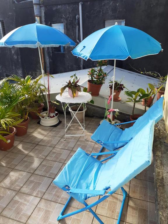 une paire de chaises et de parasols bleus sur une terrasse dans l'établissement Appartement de 2 chambres avec balcon et wifi a Sainte Marie a 6 km de la plage, à Sainte-Marie