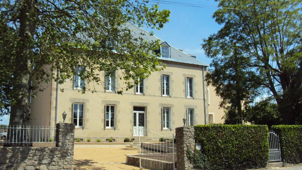 une grande maison blanche avec une clôture devant elle dans l'établissement Maison Marie Barrault, aux Herbiers