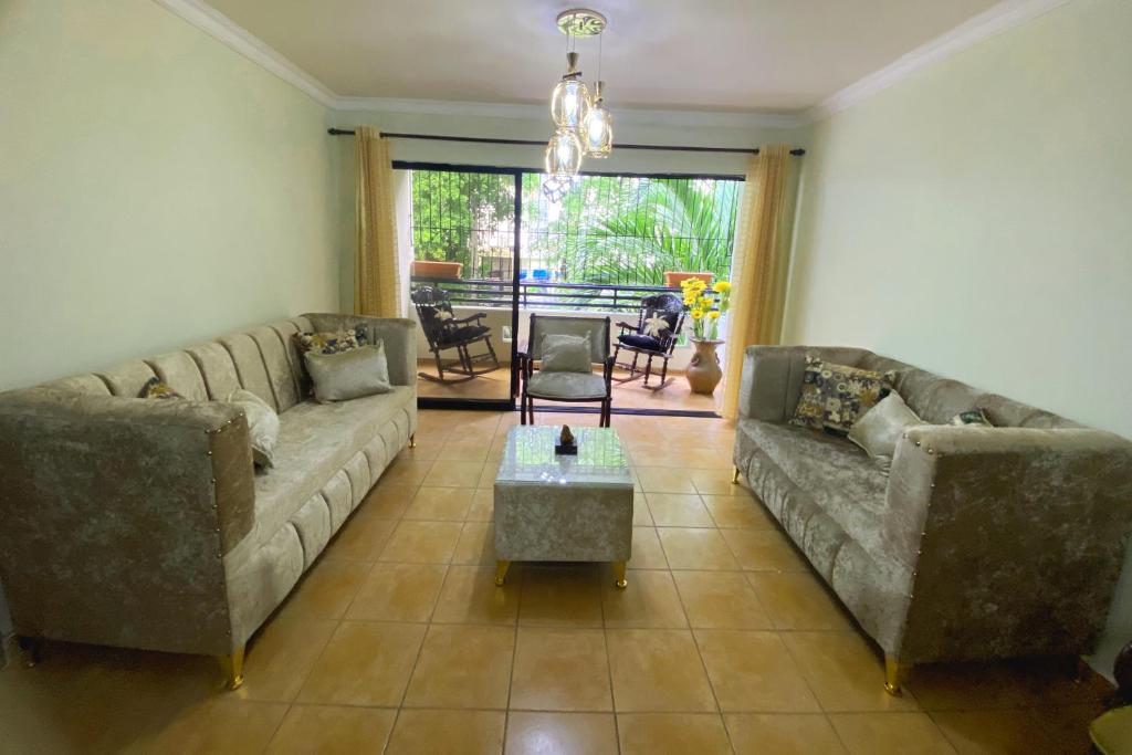 a living room with two couches and a table at Amplio apartamento en Gazcue SDQ in Santo Domingo