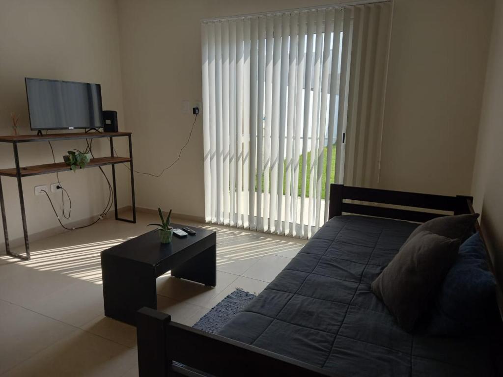 Sala de estar con cama y TV en La Cañada en Rafaela
