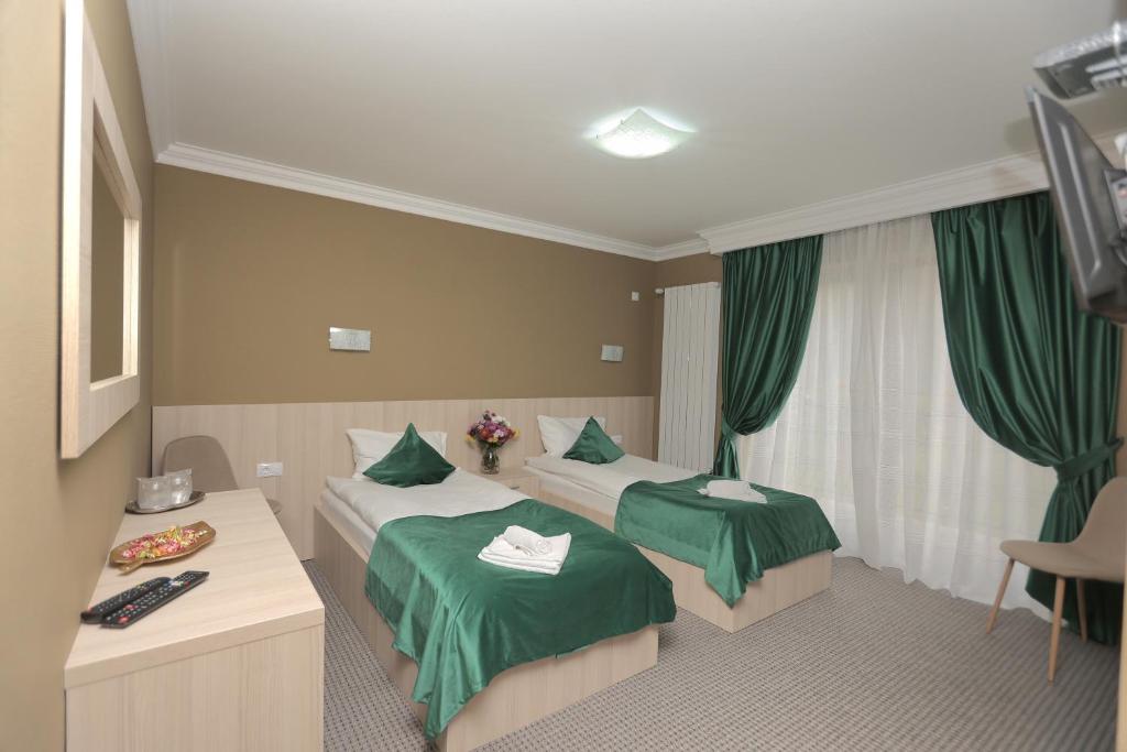 una camera d'albergo con due letti con lenzuola verdi di PENSIUNE RESTAURANT LIANA a Mehadia