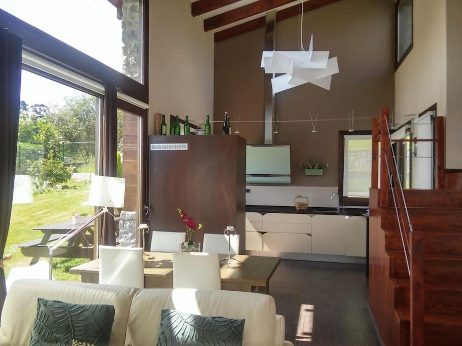 a living room with white furniture and a large window at La Casita de Eva in Colunga