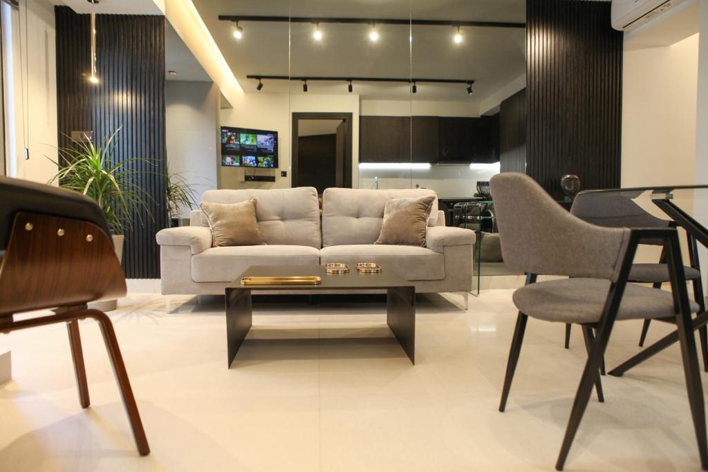 a living room with a couch and a table and chairs at Raam Luxury Suites in Larnaca