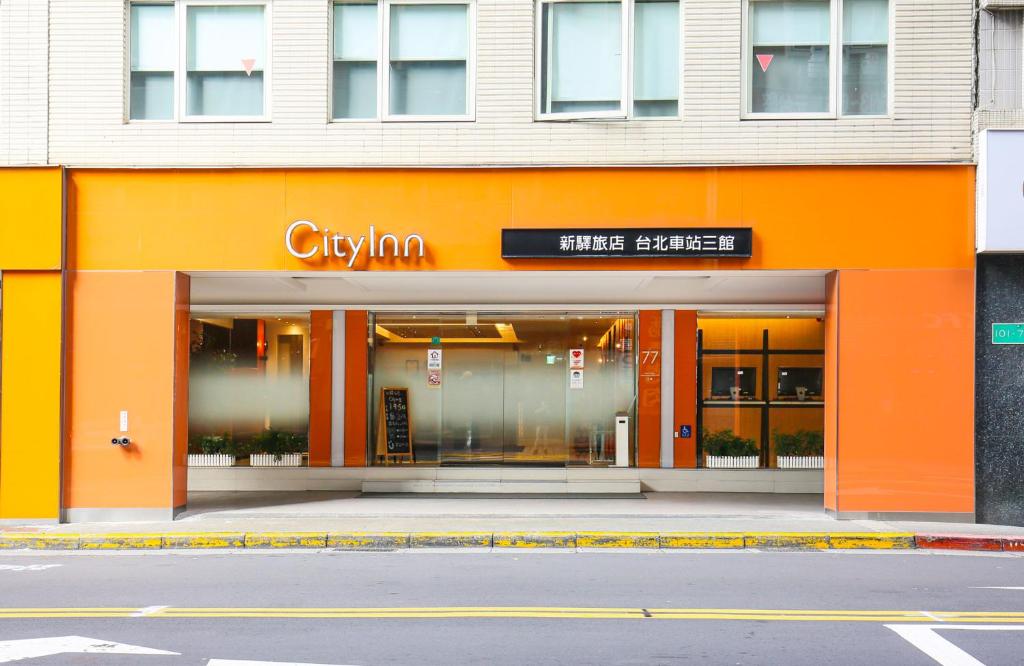 an orange facade of a store on a street at CityInn Hotel Taipei Station Branch III in Taipei