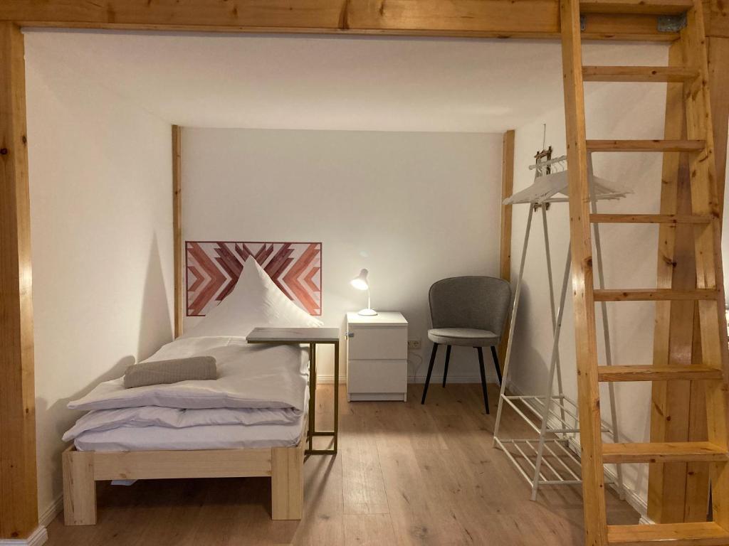 a bedroom with a bed and a ladder and a desk at Minimal Hostel No.43 in Berlin