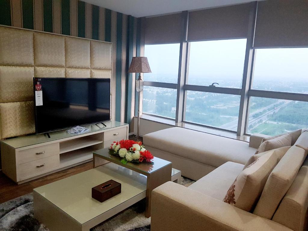 a living room with a couch and a tv at Royal Residencia Centaurus in Islamabad
