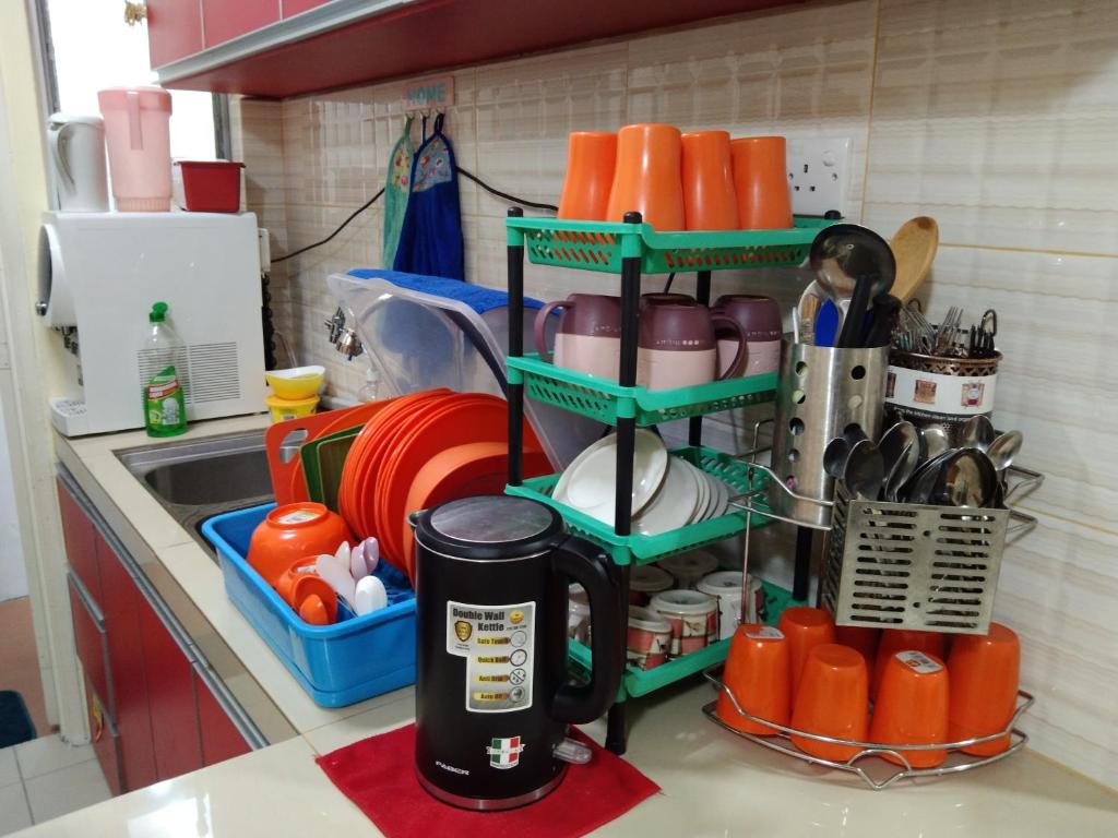 a kitchen counter with a shelf with utensils at MBI Homestay, Wakaf Che Yeh Kota Bharu in Wakaf Che Yeh