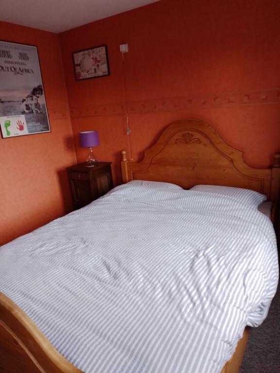 um quarto com uma grande cama branca e uma parede laranja em Bed en Breakfast met patio en kippen em Thorn