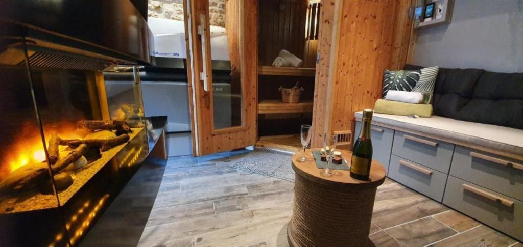 a living room with a fireplace and a couch at Le Trophée Boutique Hôtel Spa- La Loggia Appart'hôtel in Deauville