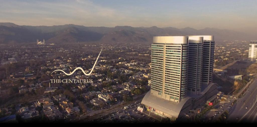une vue aérienne sur une ville avec un grand bâtiment dans l'établissement Royal Residencia Centaurus, à Islamabad