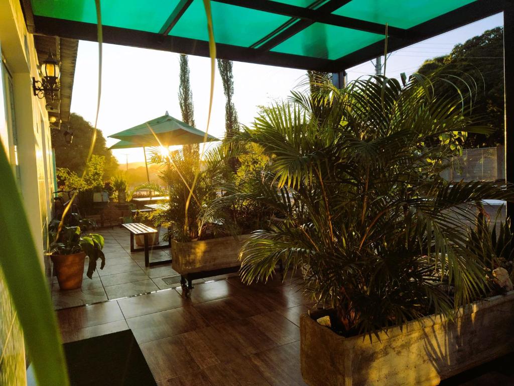 a patio with potted plants and a large window at Hotel Recanto Verde in Teresina de Goias