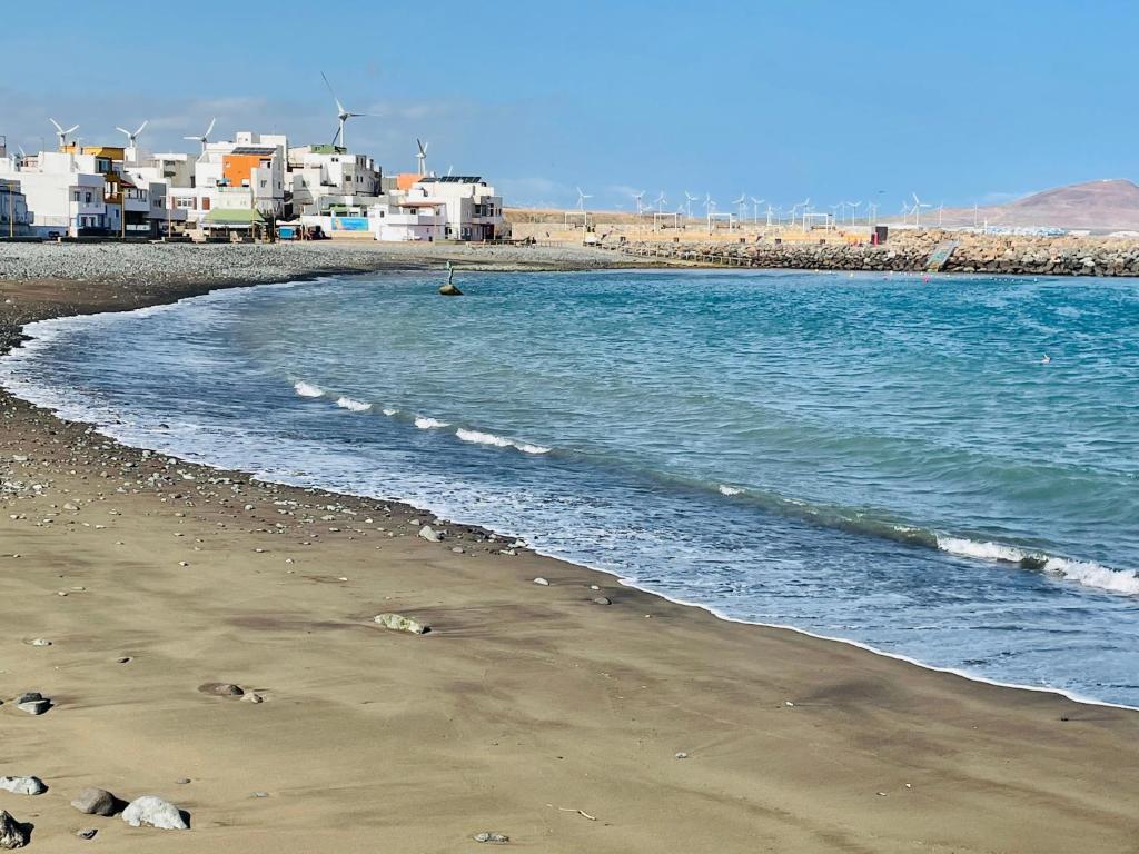 una spiaggia con l'oceano e edifici sullo sfondo di Guesthouse Ca'Artù a Pozo Izquierdo