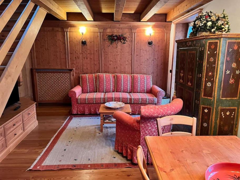 sala de estar con sofá y mesa en Mansarda su due livelli nel cuore delle Dolomiti en San Vito di Cadore