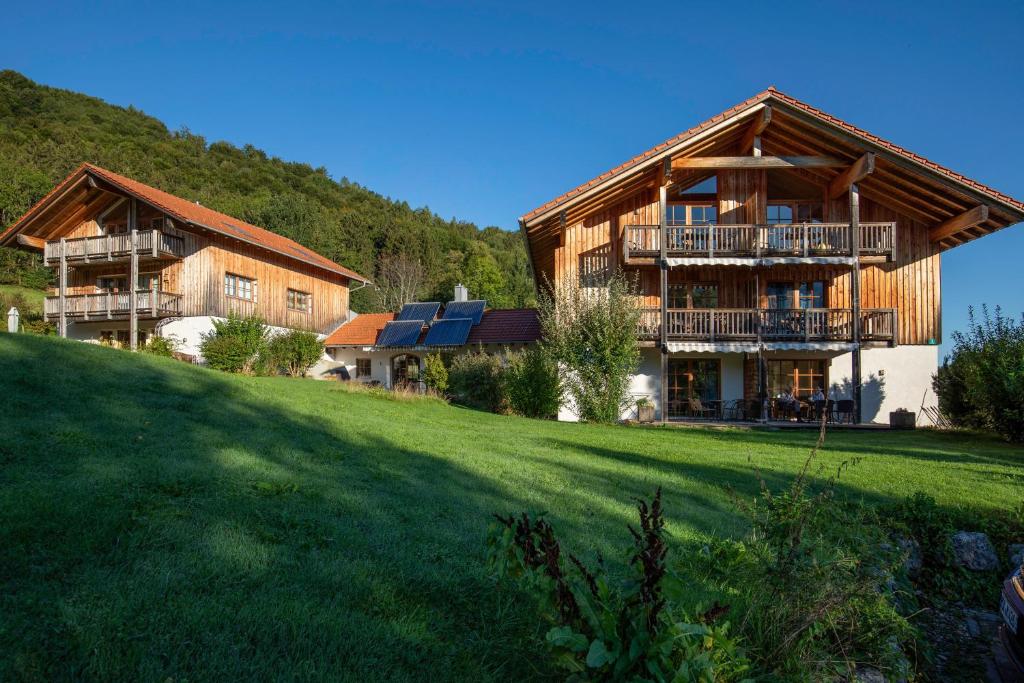 ein großes Haus auf einem Hügel mit grünem Feld in der Unterkunft Ferienwohnungen Erlebnisnaturhof in Aschau im Chiemgau