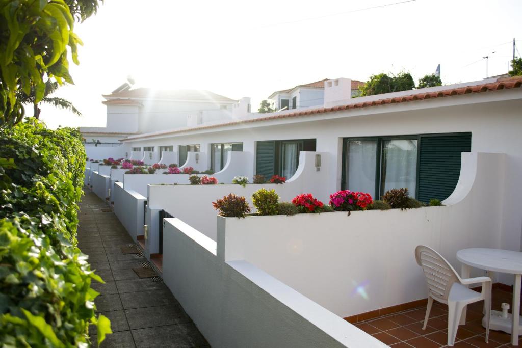 una fila de edificios blancos con flores en las ventanas en Vilas Maria, en Funchal