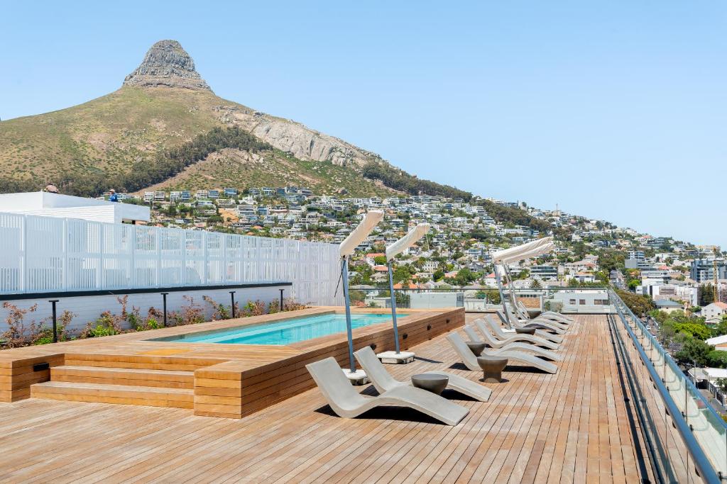 a row of lounge chairs on the roof of a building at Station House Apartments in Cape Town