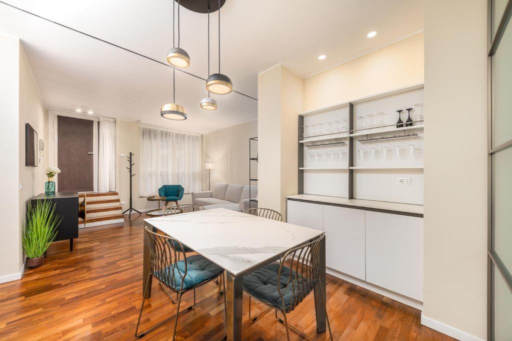 a kitchen and living room with a table and chairs at Casa da Suite Costanza in Milan