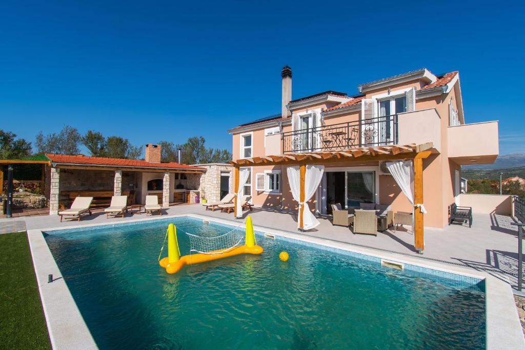 - une piscine avec toboggan en face d'une maison dans l'établissement Villa Beautiful countryside, à Drniš