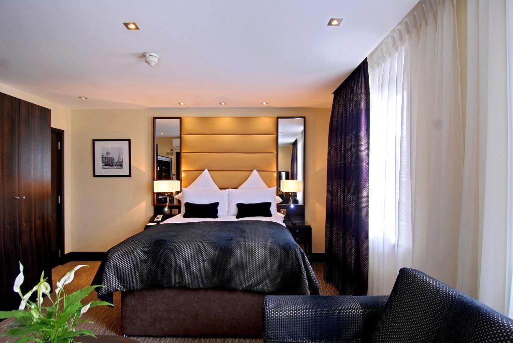 een slaapkamer met een groot bed met 2 kussens bij Montcalm Marble Arch Townhouse in Londen