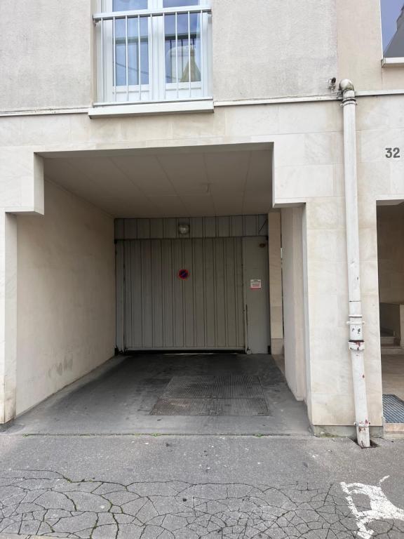 a building with a garage with a red door at Lagrive - avec VUE panoramique in Reims