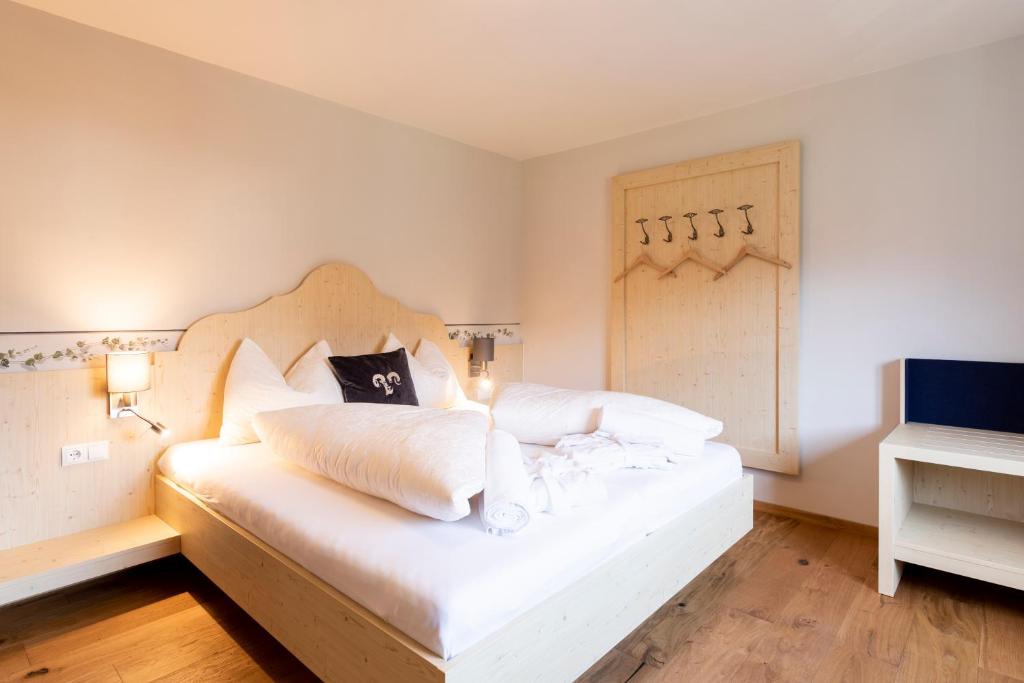 - une chambre avec un grand lit blanc dans l'établissement Residenz Theresa, à Söll