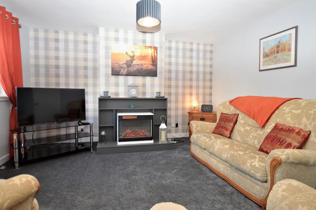 a living room with a couch and a fireplace at Anchor View in Ardrishaig